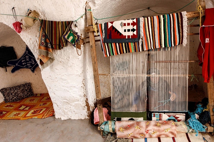 Bà Mounjia đang dệt thảm bên trong nhà - Ảnh: REUTERS