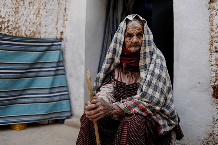 Cụ Mariem, 89 tuổi, ngồi bên ngoài nhà. Với cụ, cả cuộc đời đã sống dưới đất - Ảnh: REUTERS