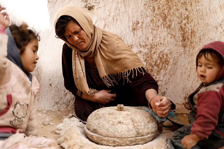 Bà Saliha Mohamedi xay lúa mì thu hoạch được - Ảnh: REUTERS