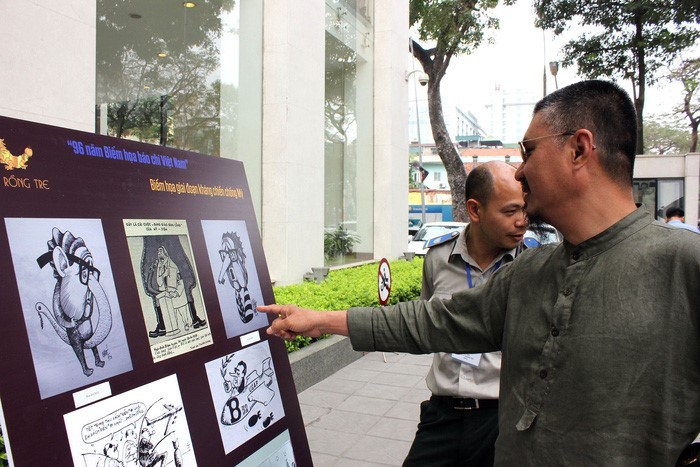 Họa sĩ Đào Hải Phong đặc biệt thích thú với các bức biếm họa của họa sĩ Chóe - Ảnh: THIÊN ĐIỂU
