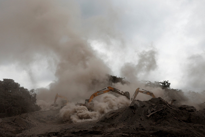 Khói bụi mù mịt tung lên khi đội cứu hộ sử dụng máy xúc đào tìm trong đống đổ nát - Ảnh: REUTERS