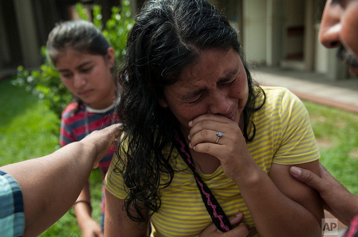 Chồng bà Lilian Hernandez đang dỗ dành vợ mình. Bà đã mất tổng cộng 36 người thân vì thảm kịch, trong đó có các cô dì chú bác, cháu, bà và 2 chắt ruột của mình. Người phụ nữ này vừa khóc vừa liệt kê từng cái tên một cho phóng viên Reuters, tại nhà thờ Mormon, nơi trú ẩn tạm thời của người tị nạn - Ảnh: AP
