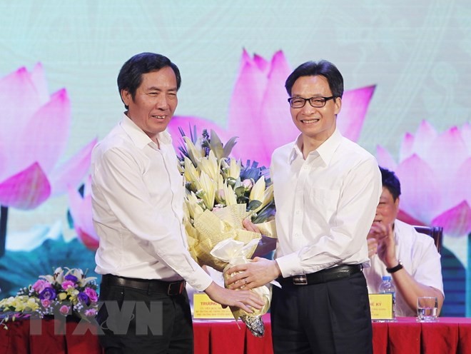 Phó Thủ tướng Vũ Đức Đam (bên phải) tặng hoa Chủ tịch Hội Nhà báo Việt Nam Thuận Hữu, chúc mừng những người làm báo trên cả nước.