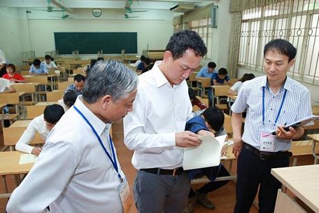 Ông Doãn Mậu Diệp - Thứ trưởng Bộ LĐTBXH (trái) và ông Kim Do - Hyon - Đại sứ quán Hàn Quốc tại Việt Nam (giữa) kiểm tra kì thi tiếng Hàn tại Hà Nội.