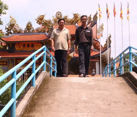 Chú Việt (bên phải) trên cây cầu mới xây từ nguồn vận động được.