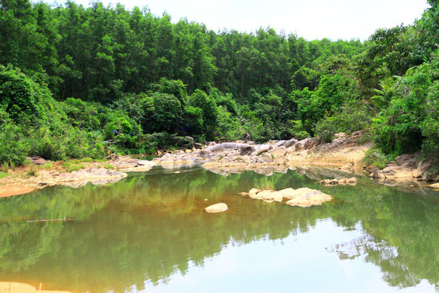 Suối được núi rừng bao quanh tạo màu xanh mát dễ chịu