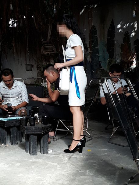 Hình chụp vào 10/8/2018 tại một quán cà phê trên đường Phan Văn Trị (quận Gò Vấp- TP Hồ Chí Minh): Một cô gái đang tiếp thị thuốc lá.