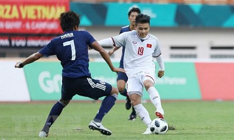 Tiền vệ Quang Hải (19) trong một pha tranh bóng với cầu thủ đội tuyển Olympic Nhật Bản. (Ảnh: Hoàng Linh/TTXVN)