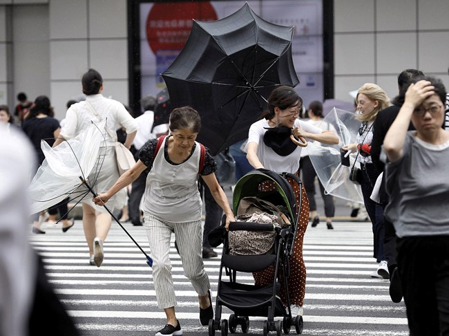 Người dân Tokyo chật vật trong gió mạnh. Tuy Tokyo không nằm trong tâm bão nhưng dự đoán đến ngày 5/9 thủ đô Nhật Bản sẽ hứng chịu mưa to và gió mạnh. Ảnh: EPA