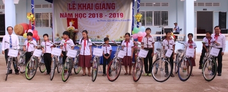 Bí thư Thường trực BCH Trung ương Đoàn TNCS Hồ Chí Minh- Nguyễn Anh Tuấn (phải) trao xe đạp cho các em
