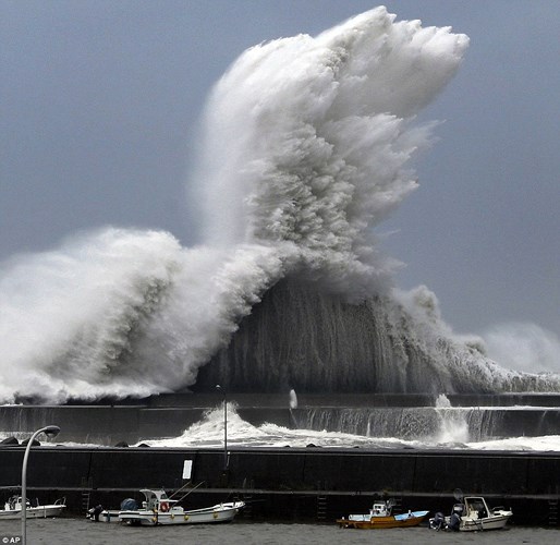 Con sóng khổng lồ như chực nuốt chửng con đê chắn sóng ở khu vực Aki, thuộc tỉnh Kochi, Nhật Bản. Ảnh: AP.
