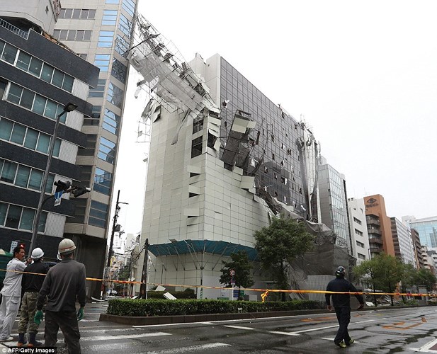 Gió mạnh thổi bay các tấm chắn bên ngoài của một tòa nhà tại thành phố Osaka. Ảnh: AFP/Getty.