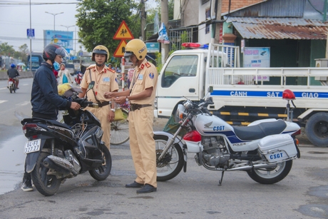 Lực lượng cảnh sát giao thông (Công an tỉnh Vĩnh Long) dừng phương tiện kiểm tra trên QL1.