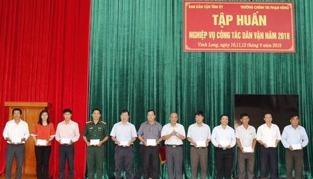 Thầy Đinh Văn Tiền- Hiệu trưởng Trường Chính trị Phạm Hùng (thứ 6 từ phải qua) trao giấy chứng nhận cho đại diện cho các sở, ban, ngành, tỉnh, các huyện, thị, thành phố tham dự lớp tập huấn.