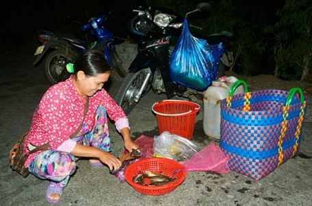  Một tiểu thương đang làm cá cho khách tại chợ “âm phủ”.