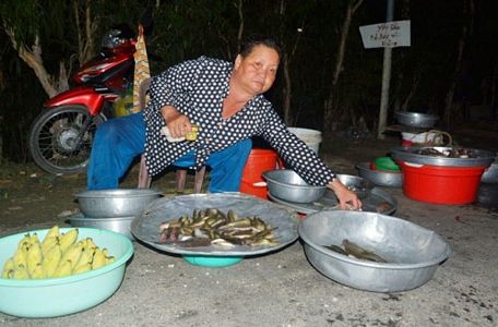  Bà Trần Thị Thủy đang phân loại cá tại chợ cá “âm phủ” Tha La