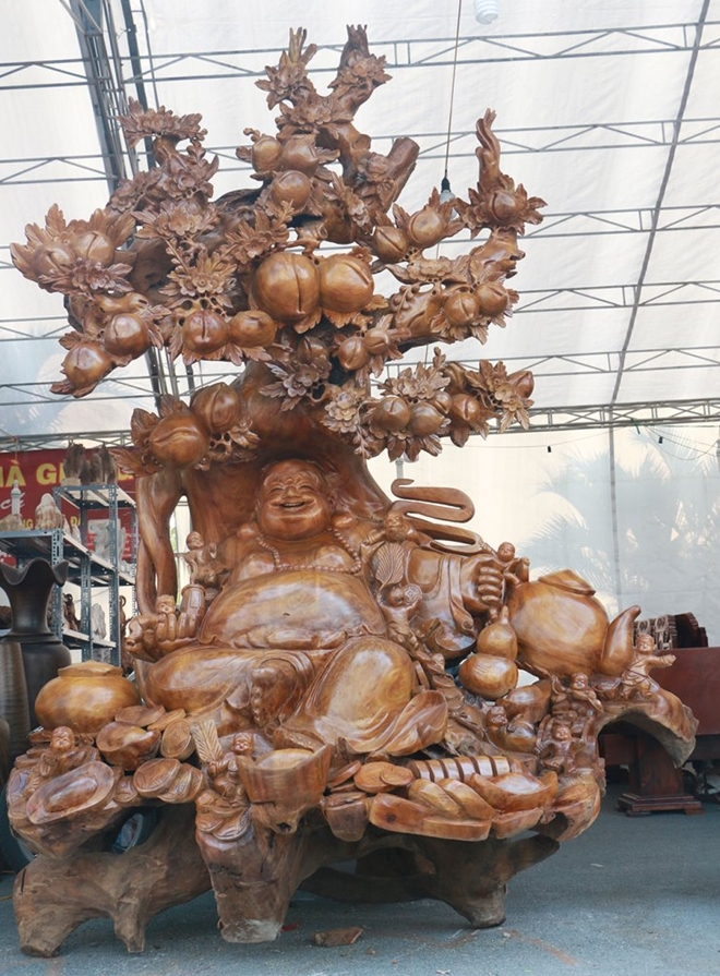 Trong khi đó bức tượng Phật Di Lạc này cũng được làm từ nguyên một thân cây. Để làm ra một bức tượng như thế này theo chủ nhân cần mất từ ba đến sáu tháng. Giá của một bức tượng như thế này cũng lên tới cả trăm triệu tuy chất liệu gỗ.