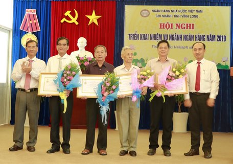 Giám đốc Ngân hàng Nhà nước chi nhánh tỉnh Vĩnh Long Nguyễn Trọng Nghiệp trao kỷ niệm chương vì sự nghiệp ngân hàng Việt Nam cho các cán bộ, lãnh đạo tỉnh và cán bộ hưu ngành ngân hàng.