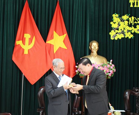Bí thư Tỉnh ủy- Trần Văn Rón (phải) trao thiệp chúc tết và tặng biểu tượng của tỉnh Vĩnh Long đến đoàn.