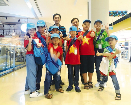 Thầy Nguyễn Minh Tuấn và các học sinh mặc áo mang màu cờ Việt Nam chuẩn bị sang Singapore.