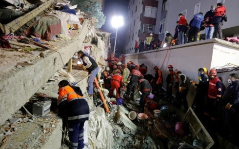 Lực lượng cứu hộ bới đống đổ nát tại nơi chung cư bị sập để tìm các nạn nhân. (Ảnh: Reuters)