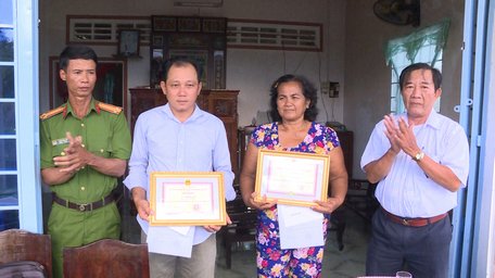 Lãnh đạo UBND xã Phú Đức trao giấy khen và tiền thưởng cho bà Quắn và anh Lợi.