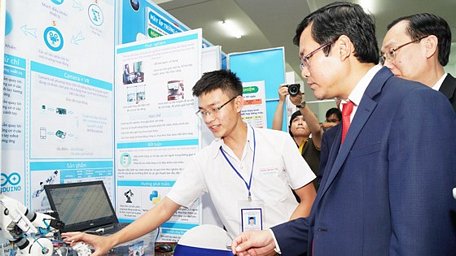 Em Thanh Giàu - Trường THPT Kon Tum đang diễn giải cho Thứ trưởng Nguyễn Văn Phúc chiếc tay robot chuyển động như tay người điều khiển. Ảnh: HOÀNG HÙNG