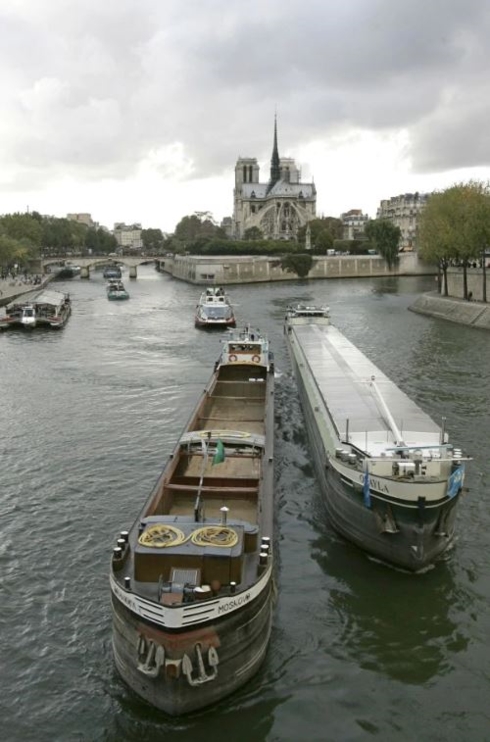 Những xà lan di chuyển thong thả trên sông Seine yên bình với Nhà thờ Đức Bà cổ kính ở phía sau.