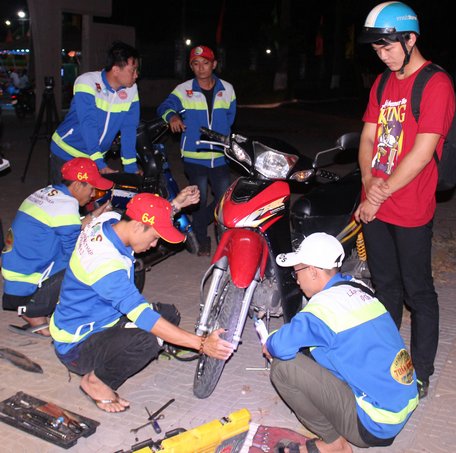 Thành viên CLB Những người bạn đường SOS Lấp Vò hỗ trợ sửa xe cho người gặp sự cố. 