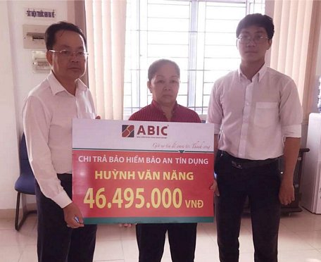 Ông Bùi Anh Phương- đại diện ABIC (bên phải) và ông Nguyễn Quang Minh- Phó Giám đốc Agribank huyện Mang Thít (bên trái)- trao biểu trưng chi trả bảo hiểm cho gia đình khách hàng.