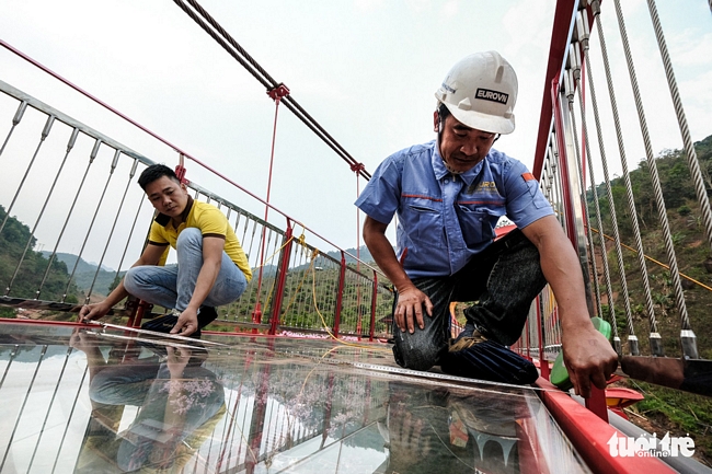Các kỹ sư tư vấn và thẩm định thực hiện kiểm tra độ an toàn của cây cầu trước khi đưa vào sử dụng - Ảnh: NAM TRẦN