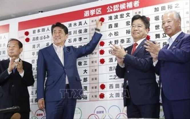 Thủ tướng Nhật Bản, Shinzo Abe gắn những bông hồng nhỏ bên cạnh tên của các ứng cử viên thắng cử của Đảng LDP sau cuộc bầu cử Thượng viện ở Tokyo ngày 21/7. Ảnh: Kyodo/TTXVN