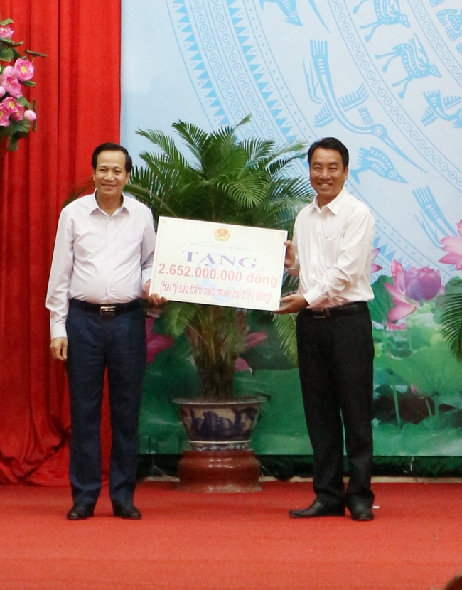 Bộ trưởng Bộ Lao động, Thương binh và Xã hội Đào Ngọc Dung (bên trái) trao bảng tượng trưng kinh phí an sinh xã hội cho tỉnh.