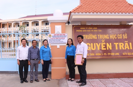Đại diện LĐLĐ tỉnh, LĐLĐ TP Vĩnh Long, đơn vị thi công và nhà trường gắn biển công trình Trường THCS Nguyễn Trãi