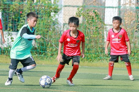 Pha tranh bóng của đội CLB Lê Thánh Tông (áo đỏ).