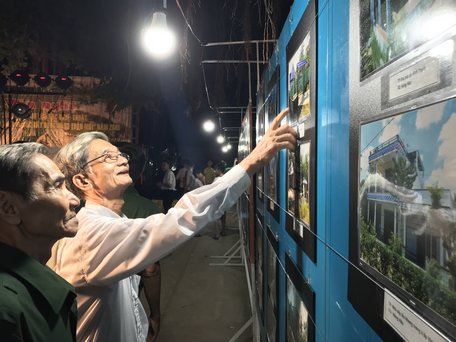 Các cụ cao niên trong xã xem tác phẩm ảnh được triển lãm.