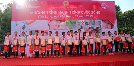 Lãnh đạo UBND tỉnh Vĩnh Long cùng đại diện Quỹ Bảo trợ Trẻ em Việt Nam, Công ty Bảo hiểm Nhân thọ AIA Việt Nam  tặng xe đạp cho các học sinh.