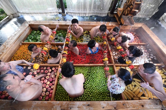 Du khách thưởng thức tiệc nướng khi tắm suối nước nóng mô phỏng theo phong cách… nồi lẩu, xung quanh là trái cây và rau củ tại một khách sạn ở Hàng Châu, tỉnh Chiết Giang, Trung Quốc ngày 27/1.