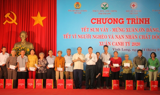 Thủ tướng Nguyễn Xuân Phúc và Bí thư Tỉnh ủy Vĩnh Long Trần Văn Rón tặng quà gia đình có hoàn cảnh khó khăn.