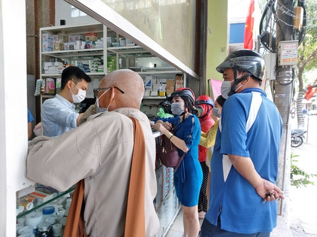 Người dân Vĩnh Long đeo khẩu trang phòng bệnh và mua khẩu trang tại nhà thuốc.