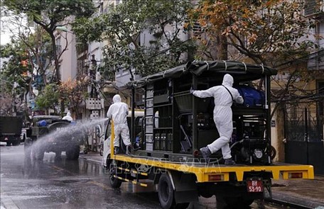 Lực lượng bộ đội hóa học phun hóa chất tiêu tẩy khu vực phố Trúc Bạch, quận Ba Đình, Hà Nội. Ảnh: Dương Giang/TTXVN