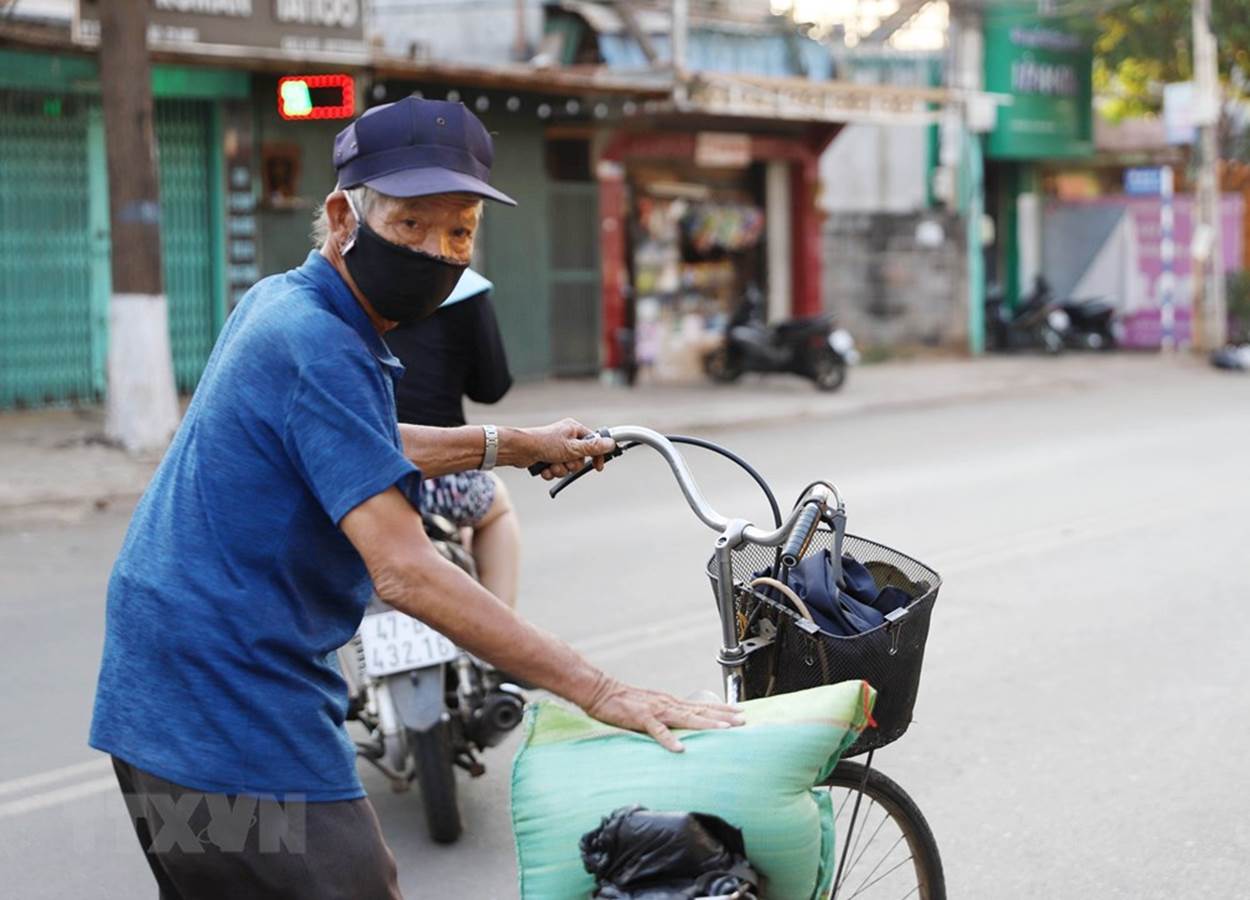  Một cụ già có hoàn cảnh khó khăn chở gạo về nhà sau khi được UBND phường Thống Nhất, thành phố Buôn Ma Thuột phát. (Ảnh: Hoài Thu/TTXVN)