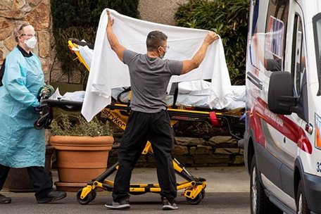 Nhân viên y tế đưa bệnh nhân Covid-19 lên xe cấp cứu tại bang Washington. Ảnh: AFP.