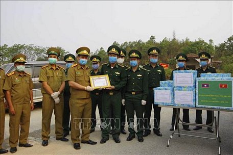 Chỉ huy Bộ đội Biên phòng tỉnh Điện Biên trao tạng vật chất phòng chống dịch cho Ty an ninh, tỉnh Phong Sa Ly. Ảnh: Phan Tuấn Anh/TTXVN