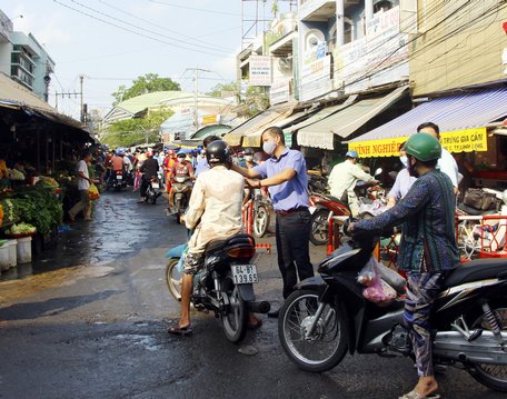 Chợ Vĩnh Long tiếp tục thực hiện đo thân nhiệt cho người dân ra vào chợ. 