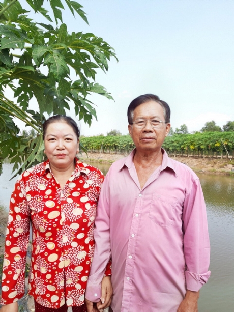 Vợ chồng ông Phước bên ao cá bống tượng của công ty.