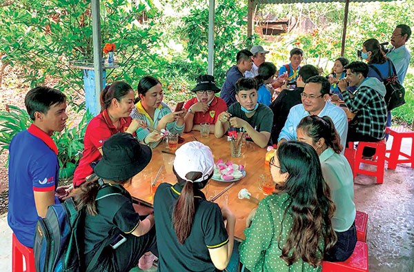 Du khách thưởng thức ẩm thực thời khẩn hoang với món cơm gói mo cau tại cồn Sơn.