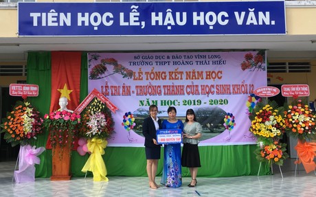Đại diện Mobifone tỉnh Vĩnh Long và Win Coffee trao bảng tượng trưng 1.000 quyển tập cho lãnh đạo nhà trường.