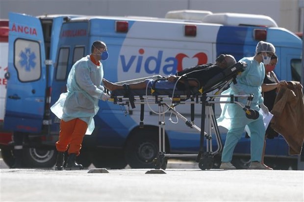 Nhân viên y tế chuyển bệnh nhân mắc COVID-19 từ xe cứu thương vào một bệnh viện ở Brasilia, Brazil. (Ảnh: THX/TTXVN)