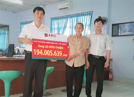 Đại diện Agribank Phòng giao dịch Mỹ Thuận và ABIC Cần Thơ- Phòng Kinh doanh Vĩnh Long trao biểu trưng chi trả bảo hiểm cho gia đình khách hàng.